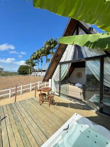 a deck with a tent and a hot tub at Rancho Navarro - Cabana A-Frame in Pôrto de Pedras
