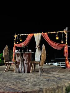 a tent with a table and chairs and lights at Rancho Navarro - Cabana A-Frame in Pôrto de Pedras