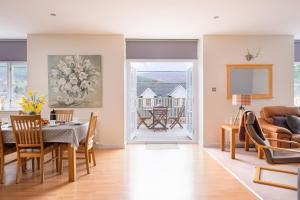 a dining room and living room with a table and chairs at Gairn Apartment in Ballater