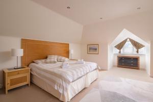 a bedroom with a large bed with a wooden headboard at Gairn Apartment in Ballater