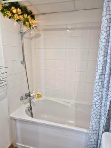a bath tub with a shower in a bathroom at L'Eden - Premium Suite - Vue - Balcon in Lourdes +27 photos
