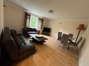 een woonkamer met een bank en een tafel bij Spacious 2-Bed Family Flat in Wimbledon Near Tube in Londen