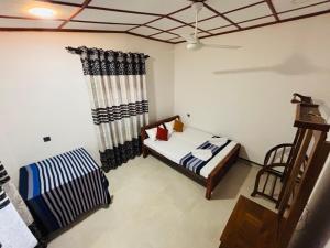 a bedroom with a bed and a ceiling fan at Madiriya Forest Lodge in Badulla