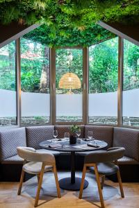 a table and chairs in a room with windows at Remisens Hotel LUCIJA in Portorož