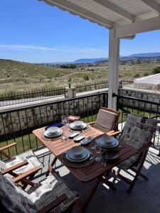 a wooden table with plates and glasses on a balcony at Villa Kataraktis in Seferihisar