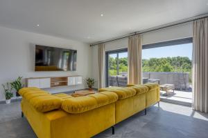 a yellow couch in a living room with a large window at Casa Mia in Rebići