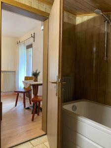 a bathroom with a tub and a room with a table at Chalet Forciagn in San Vigilio Di Marebbe +91 photos