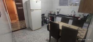 a kitchen with a refrigerator and a table and chairs at Pousada JP in Taboão da Serra