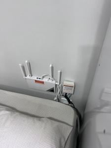 a bed with a white bed frame with a adapter at Kitinete perto da Itaipu e Unioeste in Foz do Iguaçu