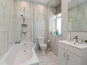 Un baño con bañera, inodoro y lavabo. en Menai View, en Menai Bridge 36 fotos más