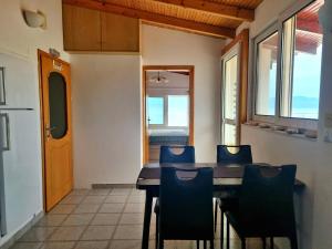 a dining room with a wooden table and chairs at Elysian Blue in Petalidi