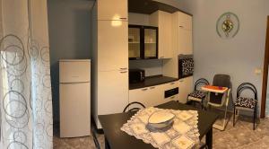 a small kitchen with a table and a refrigerator at Casa Granitto in Castello del Matese +5 photos