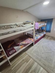 a room with two bunk beds and a rug at Arel's Home in Prizren