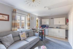 a living room with a couch and a kitchen at Lesbury Lodge - (a 'bijou residence') with hot tub in Alnwick