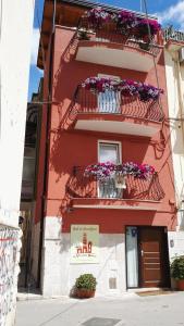 a red building with flower boxes on the balconies at B&B Al Vecchio Borgo in Barletta