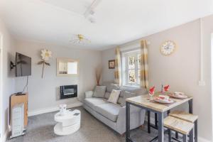 a living room with a couch and a table at Lesbury Lodge - (a 'bijou residence') with hot tub in Alnwick