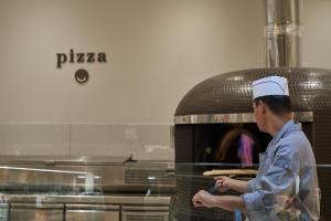 a man standing in front of a pizza oven at Atlantica Aeneas Resort in Ayia Napa +37 photos