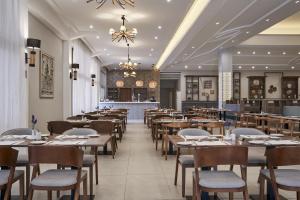 a dining room with tables and chairs and a restaurant at Atlantica Aeneas Resort in Ayia Napa