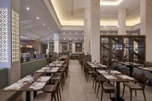 a dining room with wooden tables and chairs at Atlantica Aeneas Resort in Ayia Napa