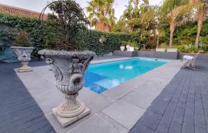 a pool in a yard with a statue next to it at La Vita e Bella in Wellington