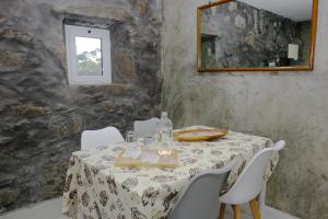 a dining room with a table and chairs and a mirror at Quinta da Baía - AL in Arrife