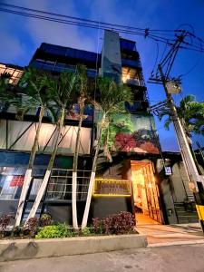 a building with palm trees in front of it at Loft Apartamentos Lleras in Medellín