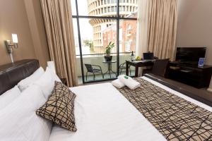 纽卡斯尔Clarendon Hotel的一间带床和大窗户的酒店房间