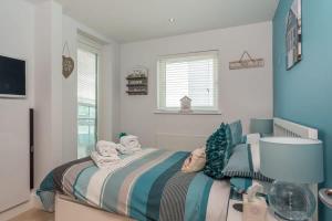 a bedroom with a bed with towels on it at Sail Away - Luxury Apartment with Stunning Harbour Views in Poole