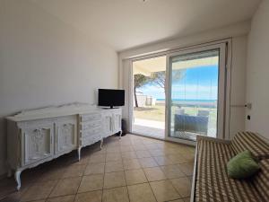 a living room with a tv and a large window at VILLA I DELFINI - Terracina Fronte Mare in Lido Di Fondi