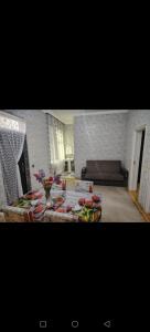 ガバラにあるGabala Cheap houseのリビングルーム(ソファ、花のテーブル付)