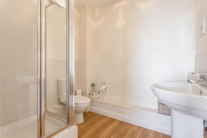 a white bathroom with a toilet and a sink at Ahoy - Balcony with Beautiful Harbour Views in Poole