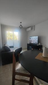 ein Wohnzimmer mit Tisch und Fernseher in der Unterkunft Anicca Alberdi Córdoba Centro in Cordoba