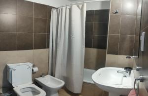 ein Badezimmer mit weißer Toilette und Waschbecken in der Unterkunft Anicca Alberdi Córdoba Centro in Cordoba + 19 Fotos
