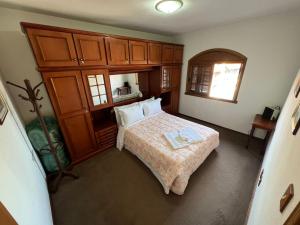 Un dormitorio con una cama y un gran armario de madera. en Apartamento a 200 metros da Rua Coberta, en Gramado