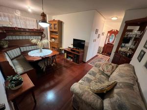 una sala de estar con un sofá y una mesa en Apartamento a 200 metros da Rua Coberta, en Gramado