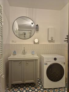 a bathroom with a sink and a washing machine at Ferienwohnung am See "Stella" in Bad Zwischenahn