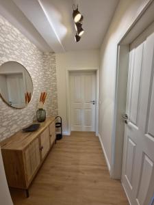 a hallway with a dresser and a mirror and a door at Ferienwohnung am See "Stella" in Bad Zwischenahn