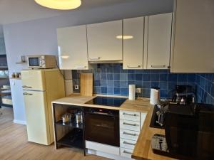 a kitchen with white cabinets and a refrigerator at Ferienwohnung am See "Stella" in Bad Zwischenahn +9 photos