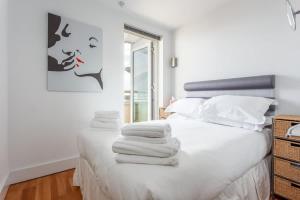 ein Schlafzimmer mit einem weißen Bett mit Handtüchern darauf in der Unterkunft Crow's Nest - On Poole Quay, Parking and Wi-Fi included in Poole