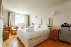 ein Schlafzimmer mit einem großen weißen Bett und einem Schreibtisch in der Unterkunft Crow's Nest - On Poole Quay, Parking and Wi-Fi included in Poole