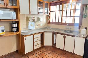 a kitchen with white cabinets and a sink at Apto central na Via Del Vino in Bento Gonçalves