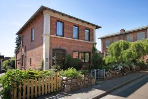 a brick house with a fence in front of it at Die Kleine Ferienvilla in Wesselburen
