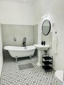 a white bathroom with a tub and a sink at Anno 1859 Vendégház in Bátaszék +29 photos