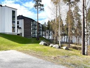 a house with rocks in the grass next to a building at Spa Chalet Erica in Virasoja