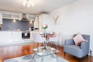 a kitchen and living room with a table and chairs at Mojo - Modern Apartment with Balcony in Poole