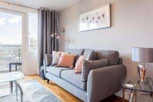 a living room with a blue couch and a window at Mojo - Modern Apartment with Balcony in Poole