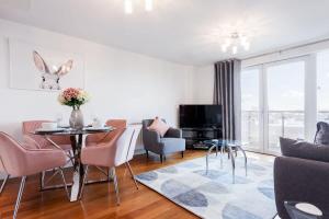 a living room with a table and chairs at Mojo - Modern Apartment with Balcony in Poole