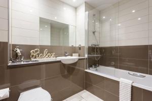 a bathroom with a toilet and a sink and a shower at Mojo - Modern Apartment with Balcony in Poole