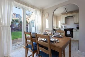 een keuken en eetkamer met een houten tafel met stoelen bij Palma - Hamworthy Beach and Park Short Walk Away in Poole
