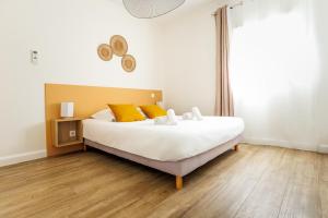 een slaapkamer met een groot wit bed met gele kussens bij Casamea - T2 A Tavagna in Talasani +29 foto's